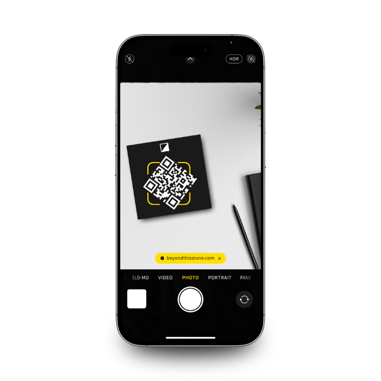 Smartphone with camera app open, scanning a QR code memorial for headstone.