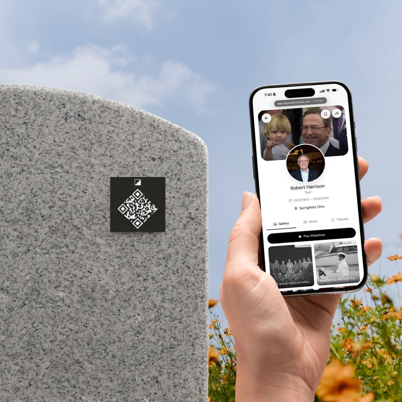A person scanning the QR plate at a headstone with their phone